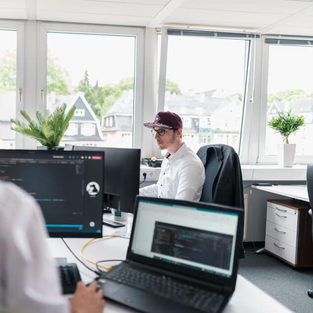 Lorent IT Mitarbeteiter von der Seite am Arbeitsplatz