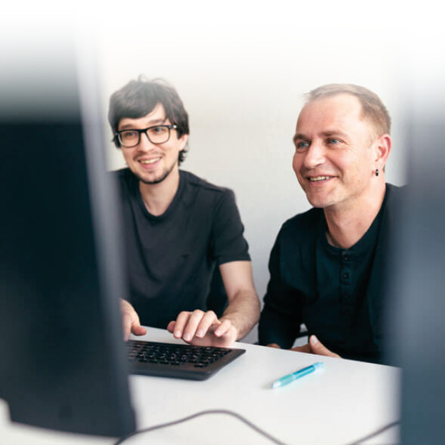 Lorent IT Mitarbeiter sitzen vor einem PC