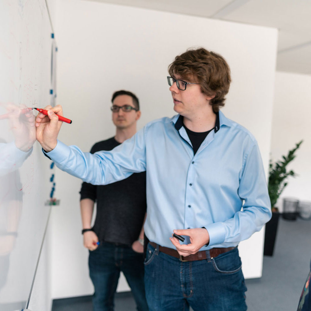 Lorent IT Mitarbeiter zeichnet mit Stift an Whiteboard