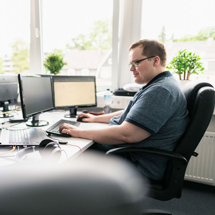 Lorent IT Mitarbeiter vor zwei Monitoren